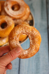 Cozy homemade donuts on rustic wooden kitchen table. Sweet dessert and comfort food concept showing cozy lifestyle, family cooking and slow living mood.