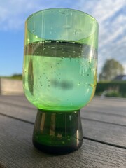 glass of sparkling water in a green glass