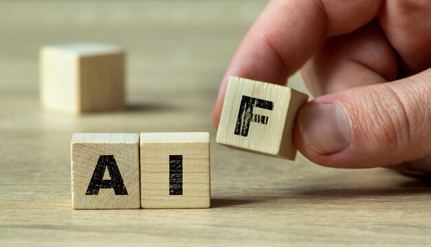 A hand is rearranging wooden blocks to spell AIF, symbolizing the growing significance of artificial intelligence and future technology in various industries.