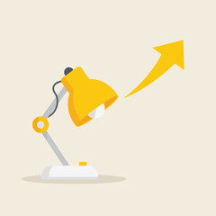 Yellow desk lamp illuminating an upward-pointing arrow, symbolizing growth.