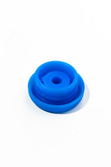 A blue plastic cap from a large 19-liter drinking water bottle lies on a white background.