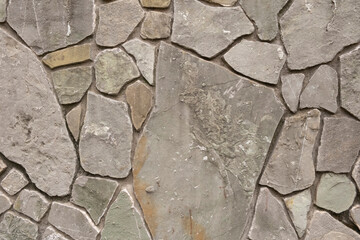 Obraz premium Stone wall made of various natural rock pieces in an outdoor setting