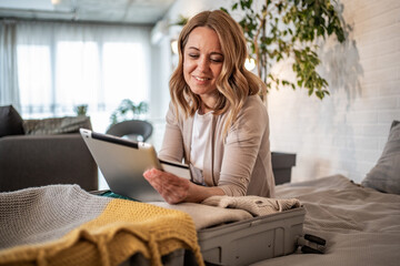 Woman booking travel accomodations online using tablet and credit card