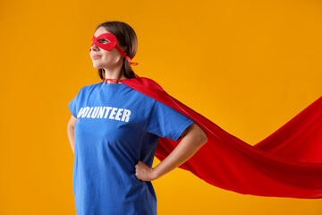 Volunteer wearing superhero costume on yellow background