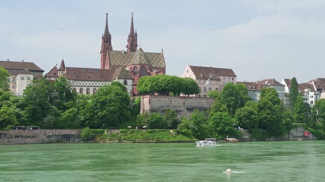 Basel, Switzerland &mdash; Scenic summer view of the Basel Cathedral (Basler M&uuml;nster) and historic old town from the Rhine riverbank