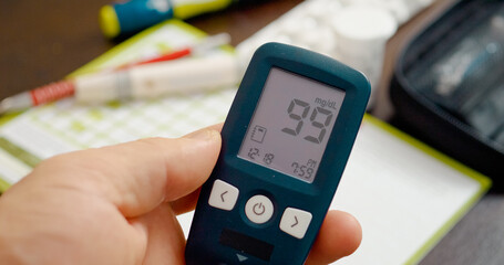 A blood sugar test result is displayed on a glucometer indicating a level of (99 mg). This result...