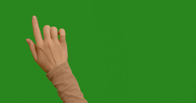 Female hand touching, clicking her finger in various places on a green screen. Female hand touching, tapping on chroma key green screen background. Interface concept. Touching Gesture.