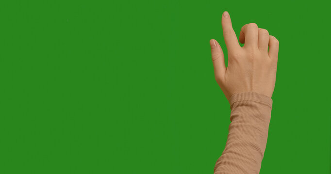 Woman swiping from top to bottom, left to right on a green screen. Female hand touching, tapping on chroma key green screen background. Interface concept. Touching Gesture.