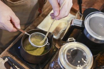 Professional barista making green tea matcha drink. focused preparation involves stirring liquid in...
