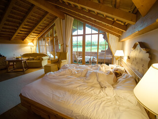 Woman having healthy sleeping hours for stress relief in bed in a chalet. Female resting relaxing after heavy night life.