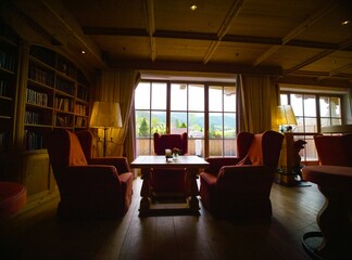 Naklejka premium Zoom in luxury armchairs and wooden table in resort. Leisure furniture and space in hotel with no people.