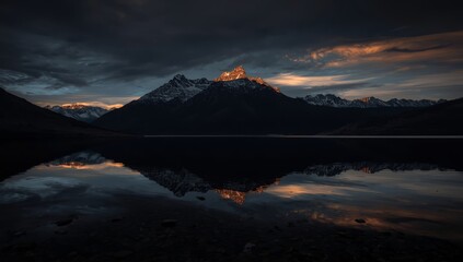 Dramatic mountain landscape with lake reflection at sunset