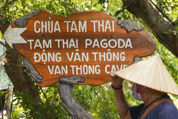 Wooden sign showing direction to the Tam Thai Pagoda and Van Thong cave, parts of the Marble Mountains, a network of caves, tunnels, towers, and pagodas in Da Nang, Vietnam