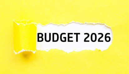 A yellow paper tornado in the middle reveals the text “Budget 2026” on a white background....