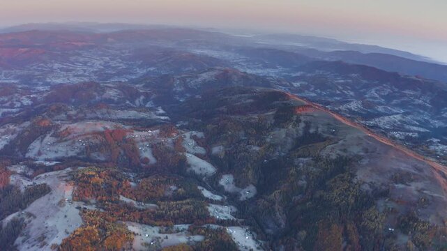 Ukraine, drone, flight in the Carpathians early autumn morning at sunrise near the city of Kosiv. Bright forests and frost of the night frost