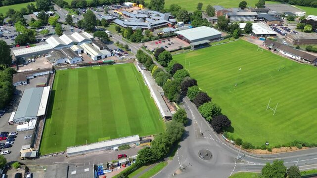 Tiverton, Devon, England: DRONE VIEWS: The drone circles various sports pitches towards the edge of town. Tiverton is the commercial and administrative centre of mid-Devon (Clip 1 of 3).