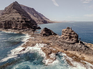 Aerial view of rugged volcanic cliffs and rock formations near Orzola, Lanzarote, surrounded by...
