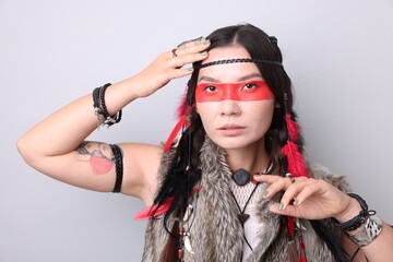 Shaman woman with face painting on light grey background