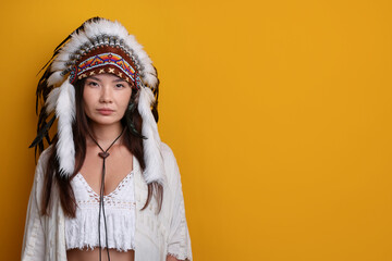 Shaman woman in native American Indian headdress on orange background, space for text