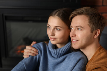 Lovely couple hugging near fireplace in room