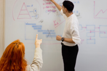 Businesspeople discussing at seminar conference. Speaker educating and sharing experiences. Successful businessman giving presentation. Audience raising hand up and pointing to ask question at meeting