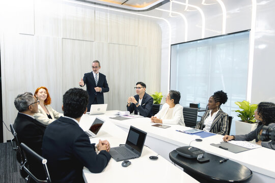 Group of diverse businesspeople at conference, happy business workers discussing and brainstorming together at meeting room. Cheerful officers exchange ideas and listen to presentations during meeting