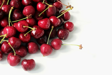 Ripe cherry, red delicious fresh organic cherry, in the upper left corner on a white background with space for text.
