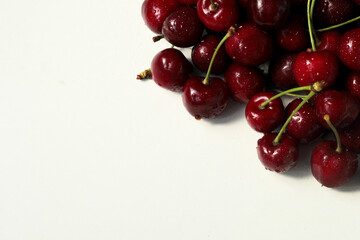 Ripe cherry, red delicious fresh organic cherry, in the right corner on a white background with space for text.