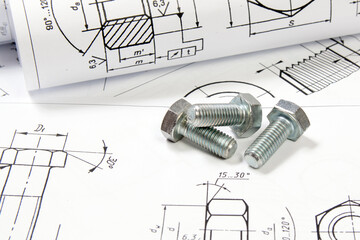 Printed engineering drawings and metal bolts. 