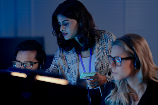 A future call center manager uses an AI platform showing predictive analytics on agent performance, identifying coaching needs in real time for optimized customer interactions.