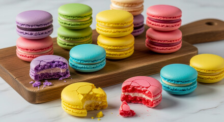 A vibrant assortment of sweet French macarons in various colors and flavors, beautifully arranged on a wooden board and white marble surface.