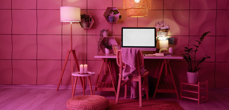Interior of dark office with workplace, shelves and glowing lamps - Powered by Adobe