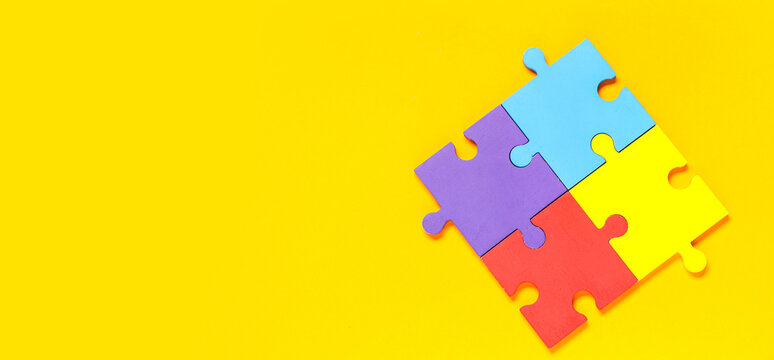 Colorful puzzle pieces on yellow background. Autistic disorder concept