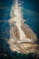Construction crews work on a high-speed train line in France, creating a path through the landscape while a highway runs parallel.