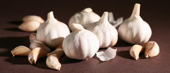 Many fresh garlics on brown background