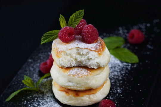 Sweet cottage cheese pancakes(sweet syrniki) on plate with raspberries