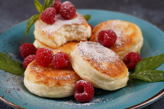 Sweet cottage cheese pancakes(sweet syrniki) on plate with raspberries