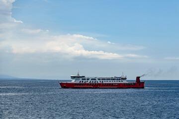 Red Ferry Boat on Blue Ocean Under Cloudy Sky