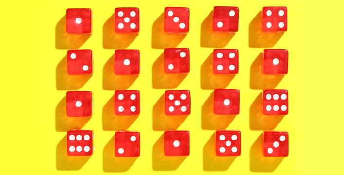 Red game dices on yellow background, top view