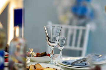 A table set with plates glasses and a bottle with a blurred background