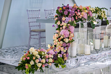 A table with a floral arrangement and candles