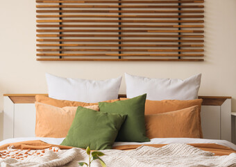 Big bed with soft pillows in light bedroom