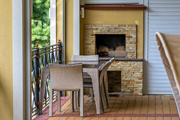 A patio with a table and chairs a brick fireplace and a view of the outdoors