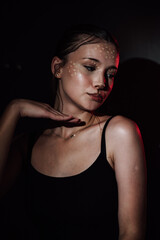 Naklejka premium Portrait of a girl on a dark background. Makeup.