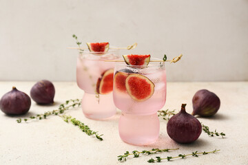 Glasses of fresh fig lemonade on white grunge table, closeup