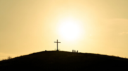 Naklejka premium Sacred Silhouette: The image captures a serene moment where a cross stands silhouetted against a radiant sunset. The cross's placement upon the hill evoke a sense of spirituality.