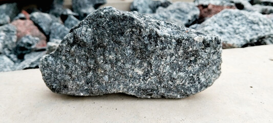 Close-Up of a Rough Granite Stone on Neutral Background. Natural Gray Rock Texture for Construction or Design Use