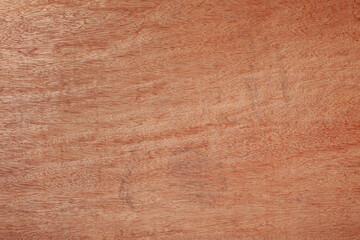 Smooth, red-brown wood plywood or veneer surface, fine, swirling wood grain pattern with subtle...