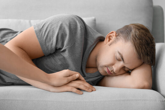 Woman supporting man with suicidal thoughts on sofa at home