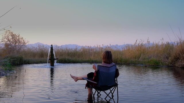 A woman with a nait in nature at the Ayak-Kalkan hot radon spring with radon water on the banks of the Ili River. Ideal for relaxation and health. Enjoy the silence and beautiful scenery.